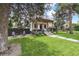 Charming two-story home featuring a well-manicured lawn and inviting front porch with wood beams at 1690 Spruce St, Denver, CO 80220