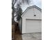 A detached garage with white siding and a one car paneled garage door at 1690 Spruce St, Denver, CO 80220