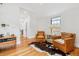 Living room with hardwood floors, two chairs, side table, and cowhide rug at 1690 Spruce St, Denver, CO 80220