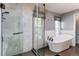 Bright bathroom featuring a soaking tub, glass-enclosed shower, and large window at 11682 E Iowa Ave, Aurora, CO 80012