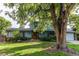 Inviting home with well-maintained landscaping, blue siding, and a welcoming front yard shaded by mature trees at 11682 E Iowa Ave, Aurora, CO 80012