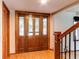 Elegant foyer featuring a decorative wood door with sidelights and wood flooring, leading to the staircase at 11682 E Iowa Ave, Aurora, CO 80012
