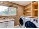 Functional laundry room featuring modern washer and dryer and ample shelving at 11682 E Iowa Ave, Aurora, CO 80012