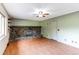 Living room with a stone fireplace and light-green paneled walls at 11682 E Iowa Ave, Aurora, CO 80012
