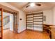 Home office featuring built-in shelves, wood floors, and a ceiling fan, offering a functional workspace at 11682 E Iowa Ave, Aurora, CO 80012
