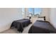 Bright bedroom with neutral carpet featuring twin beds with black bedding and a large window at 2446 W 167Th Ln, Broomfield, CO 80023