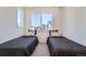 Bright bedroom featuring twin beds with black bedding and a large window offering neighborhood views at 2446 W 167Th Ln, Broomfield, CO 80023