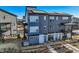 Modern three-story townhouse with blue siding, solar panels, and a cozy patio area, showcasing contemporary design at 2446 W 167Th Ln, Broomfield, CO 80023