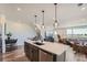 Kitchen island with seating and stainless steel appliances near living room and stairwell at 2446 W 167Th Ln, Broomfield, CO 80023