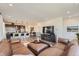 Open living room view showcases recessed lighting, a large sectional, and modern kitchen with bar seating at 2446 W 167Th Ln, Broomfield, CO 80023