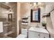 Modern bathroom featuring a glass shower, neutral tiles, vanity, and decorative shelves at 5587 S Simms Way, Littleton, CO 80127
