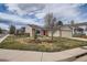 Charming single-story home featuring a brick facade, attached two-car garage, and a well-manicured front yard at 5587 S Simms Way, Littleton, CO 80127