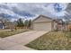 Charming single-story home featuring a brick facade, attached two-car garage, and a well-manicured front yard at 5587 S Simms Way, Littleton, CO 80127