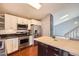 Modern kitchen with stainless steel appliances, white cabinets and a wooden island at 5587 S Simms Way, Littleton, CO 80127