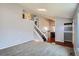 Bright, open-concept living room with modern gray walls, plush carpet, and a staircase leading to the upper level at 5587 S Simms Way, Littleton, CO 80127
