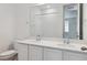Modern bathroom features double sinks, quartz countertops, and a tiled shower at 9693 Ceylon St, Commerce City, CO 80022