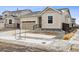 Inviting exterior view of home with a two car garage, black front door and landscaped front yard at 9693 Ceylon St, Commerce City, CO 80022