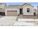 Inviting exterior view of home with a two car garage, black front door and landscaped front yard at 9693 Ceylon St, Commerce City, CO 80022