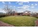 Spacious backyard with a well-maintained lawn, a covered patio, and a charming two-story brick home at 10830 Claire Ln, Northglenn, CO 80234