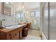 Well-lit bathroom featuring double sinks and glass shower enclosure at 10830 Claire Ln, Northglenn, CO 80234