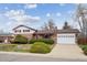 Traditional brick home featuring manicured bushes, green lawn, and attached garage on a sunny day at 10830 Claire Ln, Northglenn, CO 80234