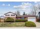 Charming brick home with a well-maintained lawn, mature landscaping, and an attached two-car garage at 10830 Claire Ln, Northglenn, CO 80234
