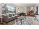 Inviting living room featuring a large window, plush sofa, patterned rug, and modern decor at 10830 Claire Ln, Northglenn, CO 80234