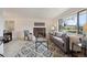 Bright living room with a brick fireplace, large window, stylish rug, and comfortable seating at 10830 Claire Ln, Northglenn, CO 80234