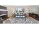 Cozy living room with a fireplace, patterned rug, large window, and comfortable grey sofa at 10830 Claire Ln, Northglenn, CO 80234