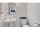Half bathroom with pedestal sink and round mirror at 28428 E 8Th Pl, Watkins, CO 80137