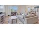 Bright living room with large windows, hardwood floors, and a comfortable gray sofa at 28428 E 8Th Pl, Watkins, CO 80137