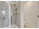 Elegant tiled shower with glass door featuring modern fixtures and finishes at 28428 E 8Th Pl, Watkins, CO 80137