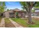 Cozy single-story home with brown siding, mature tree, and small porch area at 530 S Quitman St, Denver, CO 80219