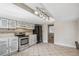 Kitchen view with stainless steel appliances, tile flooring, and abundant natural light at 530 S Quitman St, Denver, CO 80219