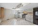 Kitchen has white cabinetry, stainless steel appliances, and checkered tile flooring at 530 S Quitman St, Denver, CO 80219