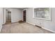 Living room with neutral carpeting, gray walls, bright window, and closet at 530 S Quitman St, Denver, CO 80219