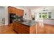 Island kitchen with wood cabinets, granite countertops, and view into living area at 5924 S Kittredge St, Centennial, CO 80016