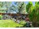 Serene backyard with a custom rock waterfall feature, lush landscaping, and mature trees at 9290 Melborne Ct, Parker, CO 80134