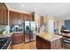 Cozy kitchen with stainless steel refrigerator, granite island, and wooden cabinets at 9290 Melborne Ct, Parker, CO 80134