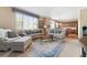 Sunlit living room with plush sofas, large window, and view to dining area at 9290 Melborne Ct, Parker, CO 80134