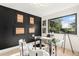 Bright home office featuring a black accent wall, glass desk, and a large window with natural light at 2140 Tabor Dr, Lakewood, CO 80215