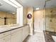 Bathroom featuring tiled shower, granite countertops, and custom cabinetry at 400 E 3Rd Ave # 305, Denver, CO 80203