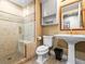 Elegant bathroom featuring a glass shower with tiled walls, toilet, sink, and vanity with gold fixtures at 400 E 3Rd Ave # 305, Denver, CO 80203