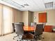 A well-lit conference room with a round table, rolling chairs, and built-in storage for professional meetings at 400 E 3Rd Ave # 305, Denver, CO 80203