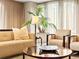 Comfortable living room featuring neutral tones, a modern sofa, and a large potted plant near bright windows at 400 E 3Rd Ave # 305, Denver, CO 80203