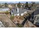 Aerial view showcases a fenced yard with a deck, complemented by mature trees and landscaping at 4493 Dunkirk Way, Denver, CO 80249