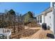Back deck area with wooden fence, white chair, greenery, and grill at 4493 Dunkirk Way, Denver, CO 80249