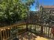 Back deck space with wooden railing and fence covered with metal leaves for privacy and shade at 4493 Dunkirk Way, Denver, CO 80249