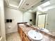 Bathroom featuring double sinks, a large mirror, and a walk-in shower with glass door at 4493 Dunkirk Way, Denver, CO 80249