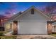 Close-up of a two-car garage featuring brick pillars, carriage lights, and a peaked roof detail at 4493 Dunkirk Way, Denver, CO 80249
